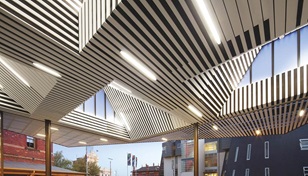 The roof cleverly folds in on itself to create multiple facets of light within, and overhangs on the outside where it forms two large awnings that address both the plaza and adjacent historic Huyghue House